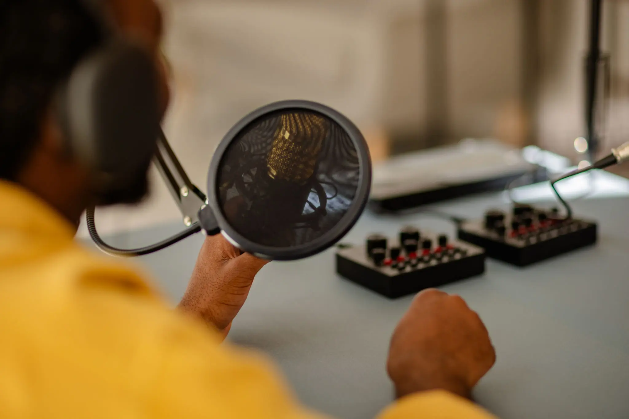 Person recording with microphone and audio equipment.