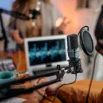 Podcast recording setup with microphone and laptop.